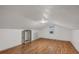 Unfinished bonus room with sloped ceilings and wood floors at 8626 Vistavia Rd, North Charleston, SC 29406