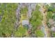 An aerial perspective shows a cozy home nestled among verdant trees, highlighting its secluded location at 1575 Tacky Point Rd, Wadmalaw Island, SC 29487