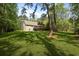 Secluded backyard with expansive lawn, mature trees, and a large deck for outdoor living at 1575 Tacky Point Rd, Wadmalaw Island, SC 29487