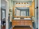 Modern bathroom with dual sinks, a large mirror, and a rustic wooden vanity at 1575 Tacky Point Rd, Wadmalaw Island, SC 29487