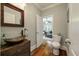 Powder room with rustic vanity, copper sink, and view to living room at 1575 Tacky Point Rd, Wadmalaw Island, SC 29487