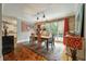 Bright dining area with wood floors, large artwork, and access to a deck at 1575 Tacky Point Rd, Wadmalaw Island, SC 29487