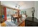 Rustic dining room with wood floors, a unique chandelier, and access to a deck at 1575 Tacky Point Rd, Wadmalaw Island, SC 29487