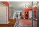 Bright entryway with hardwood floors, a statement rug, and orange walls at 1575 Tacky Point Rd, Wadmalaw Island, SC 29487