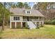 Two-story house with wraparound porch and stairs leading to the front entrance at 1575 Tacky Point Rd, Wadmalaw Island, SC 29487