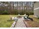Fire pit with seating in a wooded backyard at 1575 Tacky Point Rd, Wadmalaw Island, SC 29487