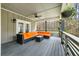 Spacious front porch with orange sectional sofa and coffee table at 1575 Tacky Point Rd, Wadmalaw Island, SC 29487