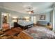 Large main bedroom with hardwood floors, a ceiling fan, and a comfortable sitting area at 1575 Tacky Point Rd, Wadmalaw Island, SC 29487
