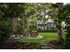 Relaxing backyard with seating area, lush landscaping, and mature trees at 1750 Ion Ave, Sullivans Island, SC 29482