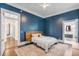 Blue bedroom with a wooden headboard, ceiling fan, and en-suite bathroom at 1750 Ion Ave, Sullivans Island, SC 29482