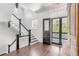 Elegant entryway with hardwood floors, grand staircase, and charming antique cabinet at 1750 Ion Ave, Sullivans Island, SC 29482