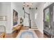 Bright entryway with hardwood floors, staircase, and statement art at 1750 Ion Ave, Sullivans Island, SC 29482