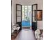 Open French doors reveal a sunlit view and a charming blue painted cabinet at 1750 Ion Ave, Sullivans Island, SC 29482