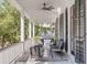 Spacious front porch with seating area, ceiling fan, and lush landscaping at 1750 Ion Ave, Sullivans Island, SC 29482