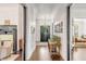 Long hallway with dark wood floors, brass light fixture, and framed artwork on the walls at 1750 Ion Ave, Sullivans Island, SC 29482