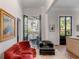 Living room with red sofa, black chairs, and French doors at 1750 Ion Ave, Sullivans Island, SC 29482