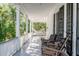 Relaxing front porch with wicker chairs and a hammock, overlooking lush greenery at 1750 Ion Ave, Sullivans Island, SC 29482
