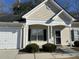 Tan house with white trim, a white garage door, and well-maintained landscaping at 214 Hardee Ave Ave, Summerville, SC 29485