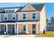 Tan and gray townhome with a covered porch and landscaping at 233 Abercom Place Dr, Moncks Corner, SC 29461