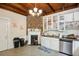 Kitchen with white cabinets, exposed brick, and wood beams at 27 Chapel St, Charleston, SC 29403