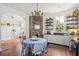 Kitchen with exposed brick, white cabinets, and a charming dining area at 27 Chapel St, Charleston, SC 29403