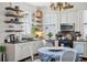 Bright kitchen boasts granite countertops, white cabinets, and open shelving at 27 Chapel St, Charleston, SC 29403
