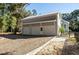 Three-car garage with metal roof, featuring a pedestrian door at 3365 Westphal Dr, Johns Island, SC 29455
