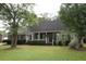 Brick house with front porch, landscaping, and large trees at 8245 Governors Walk, North Charleston, SC 29418