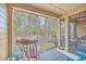 Relaxing screened porch with rocking chair, wicker furniture, and garden view at 8382 Camp Gregg Ln, North Charleston, SC 29418