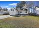 Beige house with a garage and patio, well-maintained lawn at 9609 Crosscut Dr, Ladson, SC 29456