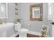 Stylish powder room with white sink, toilet, and rustic mirror at 1442 Eutaw Battalion Dr, Charleston, SC 29412