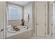 Relaxing bathroom with a soaking tub and marble tile at 1504 Rivertowne Country Club Dr, Mount Pleasant, SC 29466