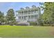 Two-story light teal house with white columns, large front porch, and manicured lawn at 1504 Rivertowne Country Club Dr, Mount Pleasant, SC 29466