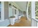 Inviting front porch with rocking chair, white railings, and potted plants at 1504 Rivertowne Country Club Dr, Mount Pleasant, SC 29466