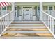 White wooden staircase leading to front door with decorative planters at 1504 Rivertowne Country Club Dr, Mount Pleasant, SC 29466