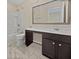 Clean bathroom with dark vanity, white toilet and bathtub, and marble-look tile floor at 1813 Towne St, Johns Island, SC 29455