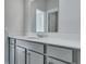 Bright bathroom vanity features a white countertop, chrome faucet, gray cabinets, and large mirror at 207 Bilge Rd, Ridgeville, SC 29472