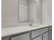 Bathroom vanity featuring a large mirror, chrome faucet, and white countertop with gray cabinetry at 207 Bilge Rd, Ridgeville, SC 29472