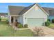 Charming one-story home with light blue siding, attached garage, and landscaped yard at 310 Bloomington Way, Summerville, SC 29486