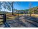 Ornate black metal gates open to reveal a charming house at 490 Cummings Chapel Rd, Ridgeville, SC 29472