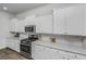 Kitchen features white cabinets, stainless steel appliances, and quartz countertops at 507 N Commodore Way, Summerville, SC 29483