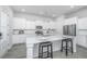 Modern kitchen with white cabinets, island with seating, and stainless steel appliances at 507 N Commodore Way, Summerville, SC 29483