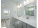 Bright bathroom features double sinks, quartz countertop, gray cabinets, and large mirror at 723 Blue Iris Way, Summerville, SC 29486