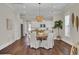 Bright dining room features a round wooden table with white chairs, hardwood floors, and a stylish light fixture at 1040 Hills Plantation Dr, Charleston, SC 29412