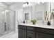 Spa-like bathroom with double sinks, marble shower, and dark gray vanity at 211 Abercom Place Dr, Moncks Corner, SC 29461