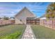 Landscaped backyard with a stone path, detached garage and wooden fence at 216 Bumble Way, Summerville, SC 29485