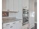White kitchen cabinets, granite countertops, and double wall ovens at 216 Bumble Way, Summerville, SC 29485