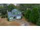 Aerial view of charming green house with driveway, surrounded by lush trees at 2336 Parkstone Dr, Charleston, SC 29414