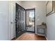 Front entry with black door, wood floors, and coat closet at 356 Peters Creek Dr, Summerville, SC 29486