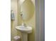 Small bathroom with pedestal sink, round mirror, and neutral walls at 705 Quintan St, Summerville, SC 29486